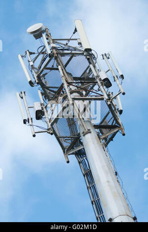 Telefono cellulare torre sorge contro un cielo blu. Foto Stock