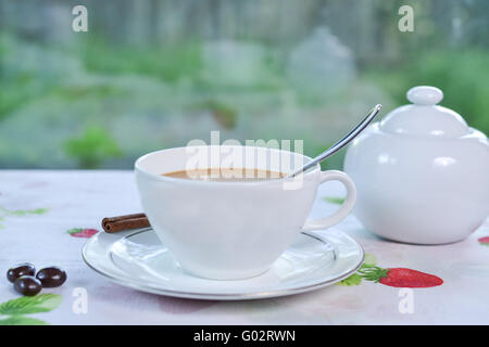 Caffè con metà e metà è servita, decorata con la stecca di cannella e zucchero la ciotola in background Foto Stock