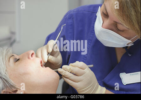 Assistente dentale nel trattamento dentale di un paziente Foto Stock