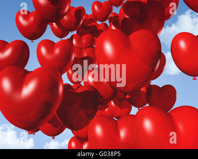 Cuore rosso palloncini sagomati fluttuante nel cielo Foto Stock