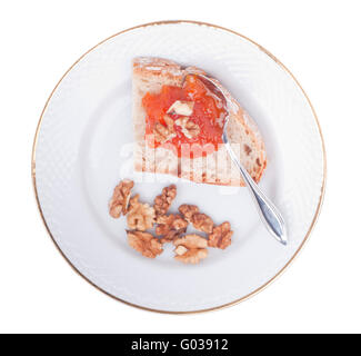 Crostini di pane casalingo con marmellata di zucca e noci su una piastra (isolato su sfondo bianco) Foto Stock