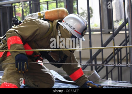 Vigile del fuoco con una maschera per la respirazione, la ricerca. Il Giappone. Foto Stock