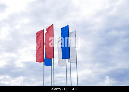 Bandiere di diversi colori contro il cielo nuvoloso Foto Stock