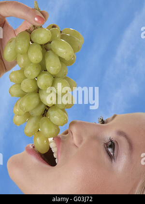 Donna con uva Foto Stock