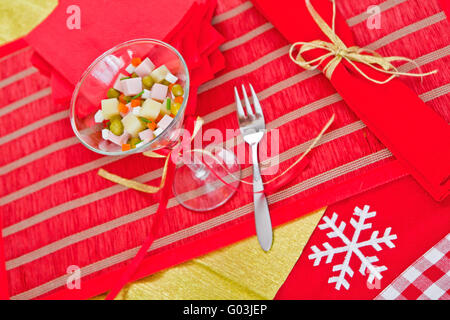 Splendidamente decorate porzione di insalata russa si erge sulla tabella di festa Foto Stock