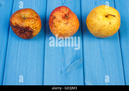 Vecchio rugoso di mele con stampo su schede di blu, cibo malsano, copiare lo spazio per testo o iscrizione Foto Stock