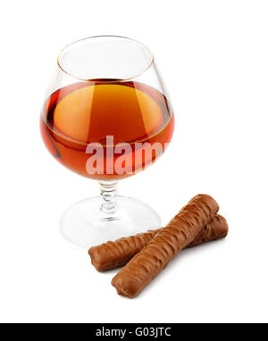 Il vetro con il cognac e il cioccolato isolato su bianco Foto Stock