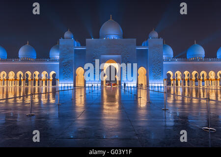 Sheikh Zayed grande moschea di notte coperto con belle luci blu e raggi di luce Foto Stock