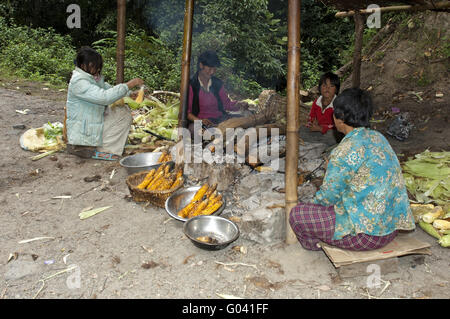 Le donne alla griglia di vendita sulla pannocchia di mais, Bhutan Foto Stock