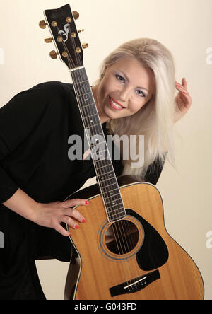 Moda giovane modello femminile in posa con la chitarra Foto Stock