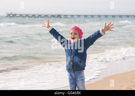 Sette anni di ragazza gioisce arrivo del mare sulla costa in primavera Foto Stock