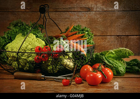 Freshly picked vegetables in metal basket on woode Foto Stock