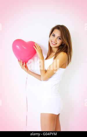 Sorridente ragazza con un grande cuore decorativo Foto Stock