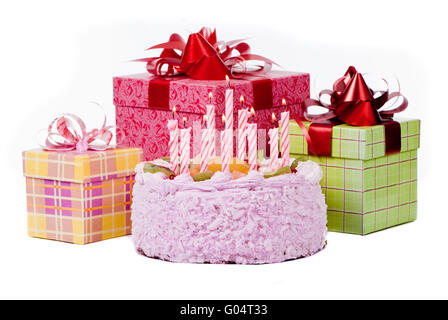 Torta con dieci candeline e doni in scatole su sfondo bianco Foto Stock
