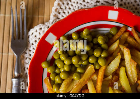 Patate fritte con piselli verdi Foto Stock