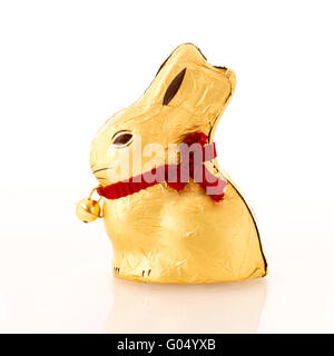 Il cioccolato di lamina di oro di coniglio avvolto contro uno sfondo bianco. Foto Stock