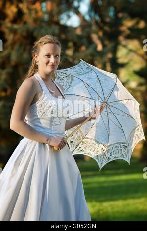 Bella Sposa ritratto con ombrellone in posizione di parcheggio Foto Stock