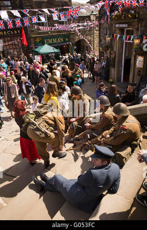 Regno Unito, Inghilterra, Yorkshire, Haworth 40s Weekend, giovani uomini in uniforme in appoggio sui gradini della chiesa Foto Stock