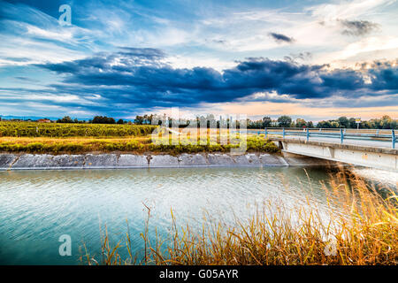 Ponte sul canale grande deviazione di acqua di fiume per irrigazione dei campi coltivati Foto Stock