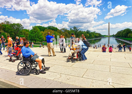 Washington DC, Stati Uniti d'America - 2 Maggio 2015: il veterano di guerra e il suo custode di onorare il volo presso il Lincoln Memorial riflettendo la piscina. Il Monumento a Washington sullo sfondo. Foto Stock