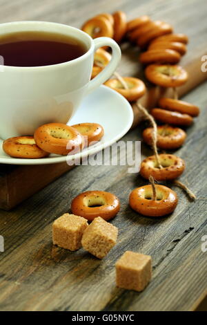 Tazza di tè e piccole ciambelle con semi di papavero. Foto Stock