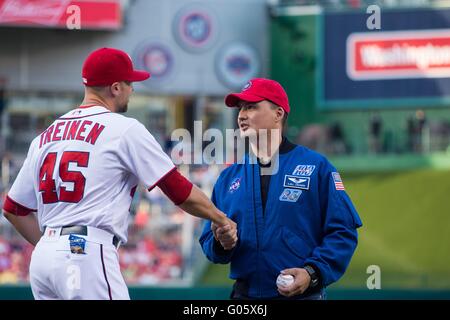 L'astronauta della NASA Kjell Lindgren scuote le mani con il bricco Blake Treinen dopo che egli ha gettato fuori il cerimoniale di primo passo prima di Washington cittadini prendere sul Philadelphia Phillies a cittadini Park Aprile 26, 2016 a Washington, DC. Lindgren ha trascorso 141 giorni a bordo della Stazione Spaziale Internazionale come parte delle spedizioni 44 e 45. Foto Stock