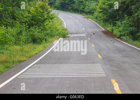 Simboli di linea del traffico su strada prima della curva Foto Stock