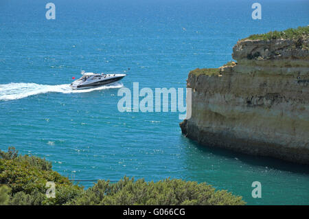 Imbarcazione turistica visitando le scogliere e le grotte vicino Albandeira beach, un'attrazione popolare fra i turisti durante la stagione estiva Foto Stock