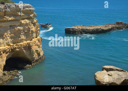 Imbarcazione turistica visitando le scogliere e le grotte vicino albandeira beach, un'attrazione popolare fra i turisti durante la stagione estiva Foto Stock