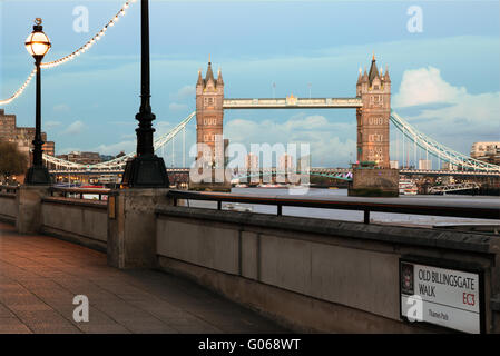 Vista serale del Tower Bridge di Londra dal vecchio Billingsgate a piedi, Thames Path. L'immagine mostra anche tipico London street segno. Foto Stock