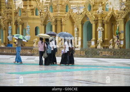 Persone sotto la pioggia alla Shwedagon, Yangon, Birmania Foto Stock