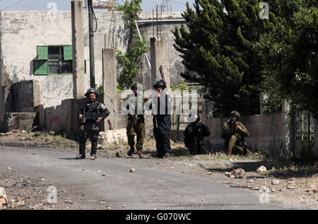 Nablus, West Bank, Territorio palestinese. 29 apr, 2016. Forze di sicurezza israeliane mirano a dimostranti palestinesi durante scontri a seguito di una dimostrazione contro l'espropriazione delle terre palestinesi da parte di Israele del 29 aprile 2016 nel villaggio di Kfar Qaddum, nei pressi di Nablus, nei territori occupati della Cisgiordania Credito: Nedal Eshtayah APA/images/ZUMA filo/Alamy Live News Foto Stock