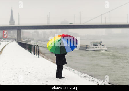 Una donna sola sorge in inverno sulle rive del Foto Stock