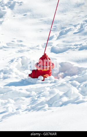Rosso fuoco idrante affondato nella neve Foto Stock