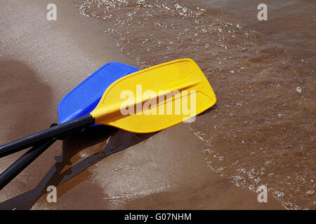 Due pale posa sulla sabbia bagnata riverbank Foto Stock