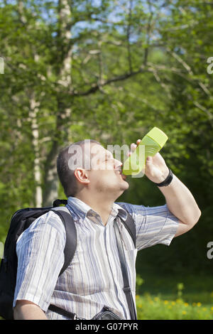 Escursionista di bere acqua da bottiglie sui sentieri forestali Foto Stock