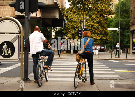 Due ciclisti di città in attesa ad un semaforo Foto Stock