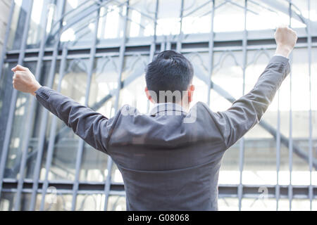 Giovane uomo d affari con i bracci sollevati urlando Foto Stock