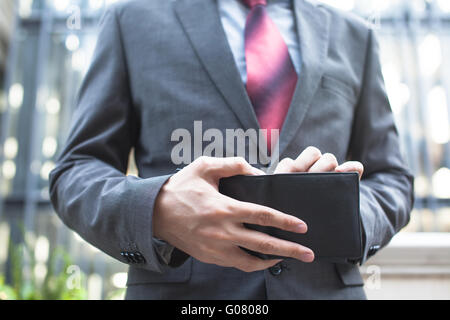 Business man tenendo le fatture al di fuori del portafoglio Foto Stock