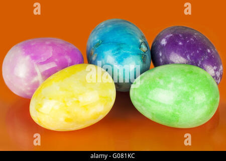 Uova di Pasqua in diversi colori su un arancione indietro Foto Stock