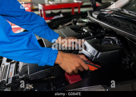 Il controllo meccanico ed il fissaggio rotto un auto in auto di servizio garage con spazio di copia Foto Stock