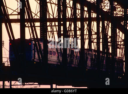 Setti commuter train attraversando ponte in West Philadelphia, Pennsylvania; al crepuscolo Foto Stock