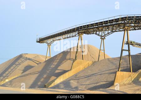 Montagne di sabbia e ghiaia nella cava di ghiaia Foto Stock