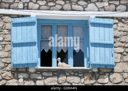 Finestra di casa in pietra con blu brillante chiusa in legno Foto Stock