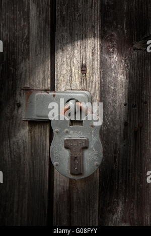 Moody capannone di illuminazione scudiero lucchetto sullo spiovente rustico sfondo legno Foto Stock