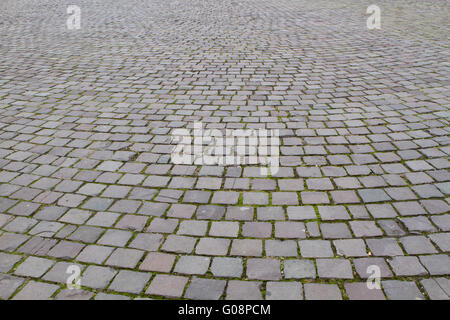 Primo piano su una strada acciottolata pattern contrasty background dovuto a un lato la luce solare Foto Stock