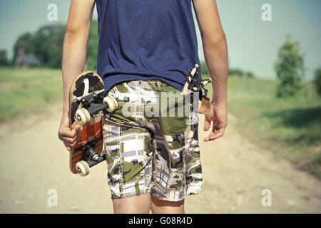 Ragazzo con lo skateboard e slingshot in tasca sulla ru Foto Stock