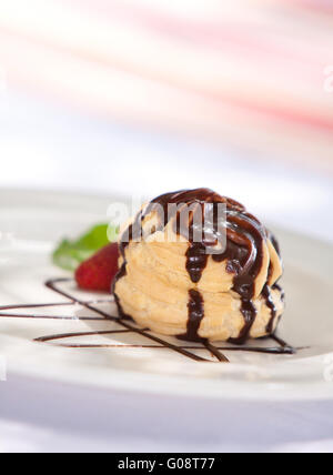 Profiterole al cioccolato con crema di ghiaccio su una piastra Foto Stock