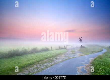 Modo di mulino a vento nella nebbia mattutina Foto Stock