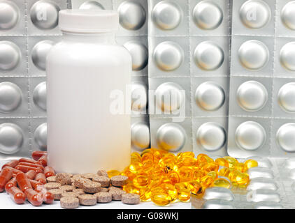 Liquido giallo capsule e piastre argenteo di medic Foto Stock